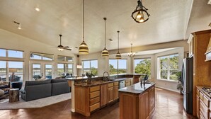 A spacious kitchen with a large island, wooden cabinets, and pendant lighting. - Paradise by the lake - Lonestar Lakehouse (Temple)