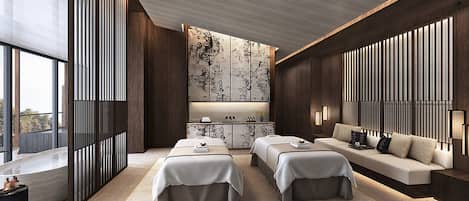 Habitación de hotel moderna con un ventanal grande, un sofá, dos camas, suelo de madera y un detalle decorativo en la pared.