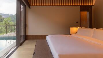Un dormitorio con cama, una banca y vista a una piscina.