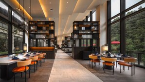 A modern hotel lobby with a long reception desk, seating area, and large windows offering a view of the outdoors. - Ahn Lan Xinchang (Shaoxing)
