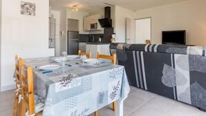 A compact living space with a dining area, kitchenette, and a sofa. - Côté du Lac by Interhome (Soustons)