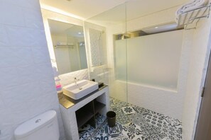 A bathroom with a white sink, mirror, and shower. - Royal Regantris Cendana (Surabaya)