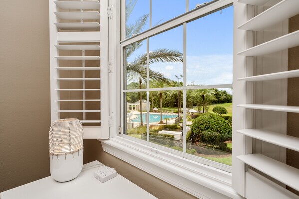 A room with a large window overlooking a pool and garden. - Immediately Adjacent to the Pool & Golf Course Views (Kissimmee)