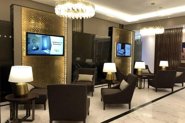 Relax in style with a flat-screen TV, comfortable seating, and a stunning chandelier.