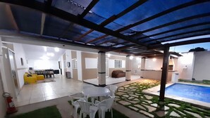 An indoor/outdoor living area with a pool, seating, and a kitchen. - Exclusive Pool  (Planaltina)