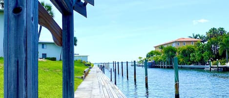 A wooden boardwalk extending over water, with a building in the background.