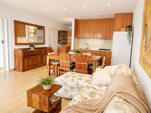 Um espaço compacto com área de refeições, cozinha compacta e sofá.