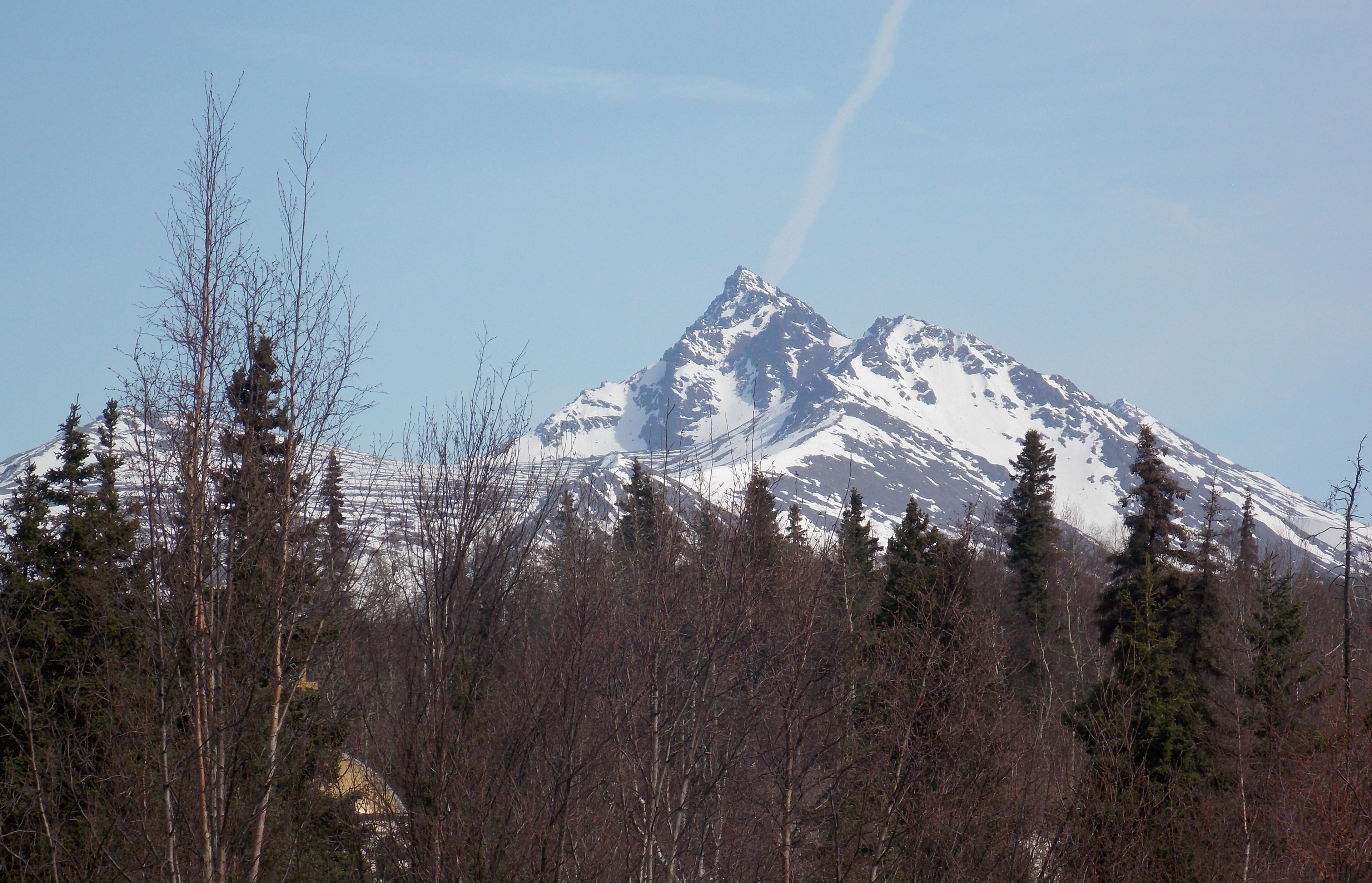 A snow-covered mountain with a clear sky.
