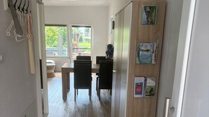 A hallway with a dining area, a wooden door with informational cards, and a view of the outdoors. - Moni's chicken farm Pure nature Outdoor pool for shared use (Nettetal)
