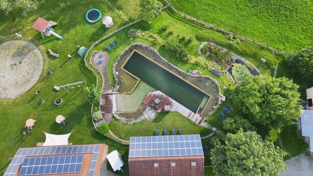 An aerial view of a property with a swimming pool, solar panels, and a fenced garden area. - Ferienhof Metzler 1 Zi. Appartement Apfel (Bodnegg)