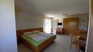 A bedroom with a bed, a chair, a desk, and a wardrobe. - Ferienhof Metzler 1 Zi. Appartement Apfel (Bodnegg)