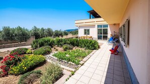 A modern house with a patio, a garden, and a view of the landscape.