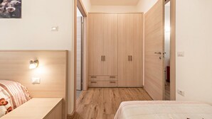 Une chambre à coucher avec un lit en bois, une armoire et une table de chevet.