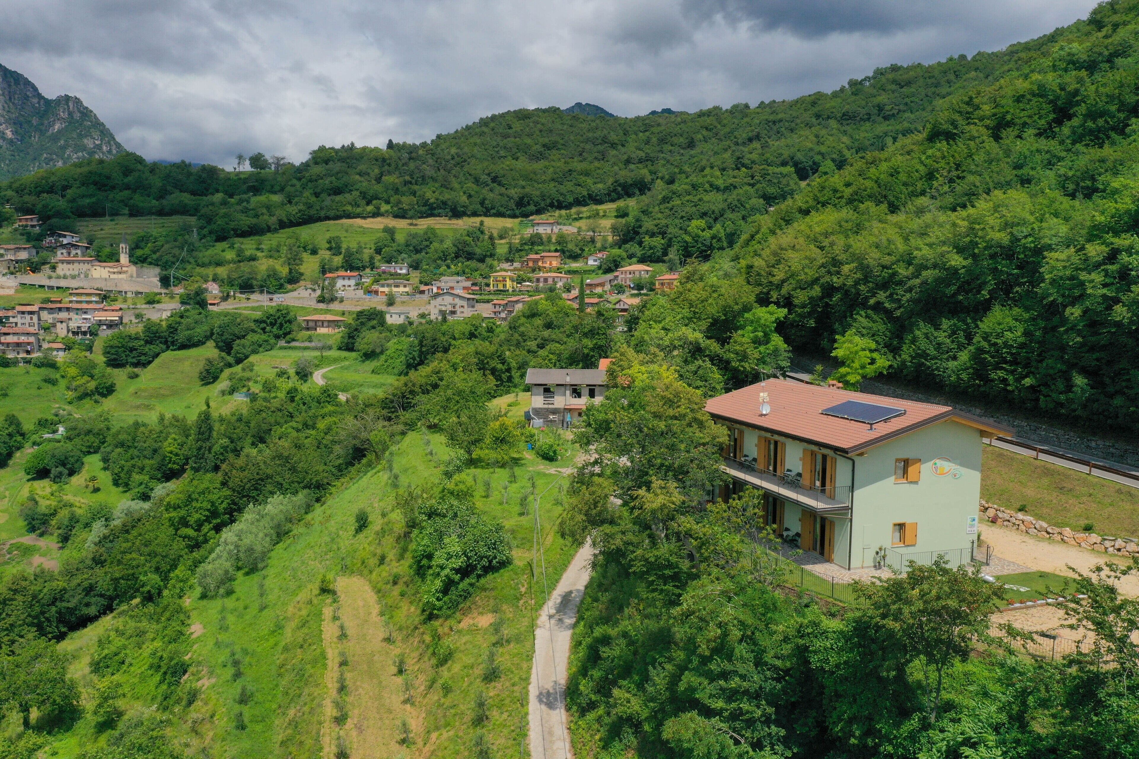 Un village perché sur une colline, avec des maisons traditionnelles, une route et un bâtiment moderne doté d’un panneau solaire.