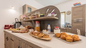Un comptoir de cuisine avec divers aliments, une machine à café et une horloge au mur.
