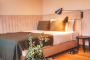 A bedroom with a bed, bedside lamp, and a potted plant. - STAY&CO Lisbon Marques de Pombal (Lisbon)