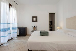 Ein Hotelzimmer mit einem Bett, einem Schminktisch, einem Sessel und einer Lampe.