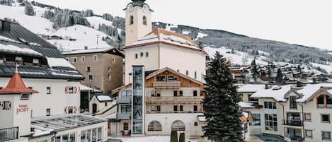 A snow-covered town with a prominent church, a hotel, and traditional buildings.