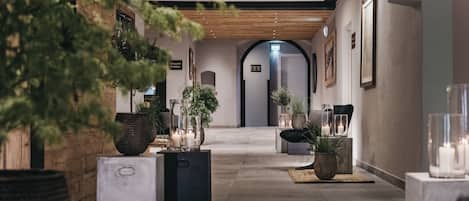 Un moderno vestíbulo de hotel con techo de madera, plantas en macetas y una recepción.