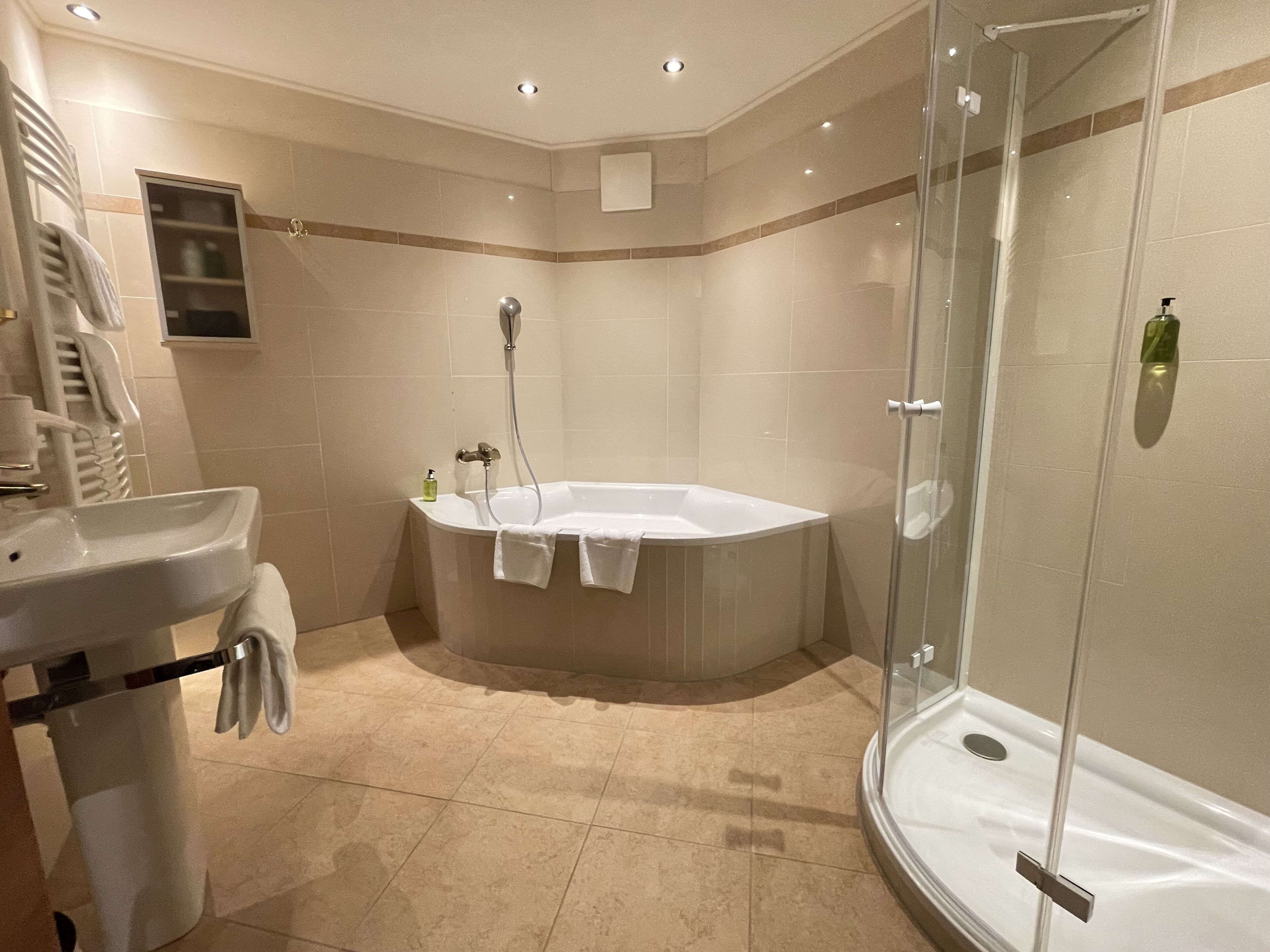 A modern bathroom with a sink, a bathtub, and a glass-enclosed shower.