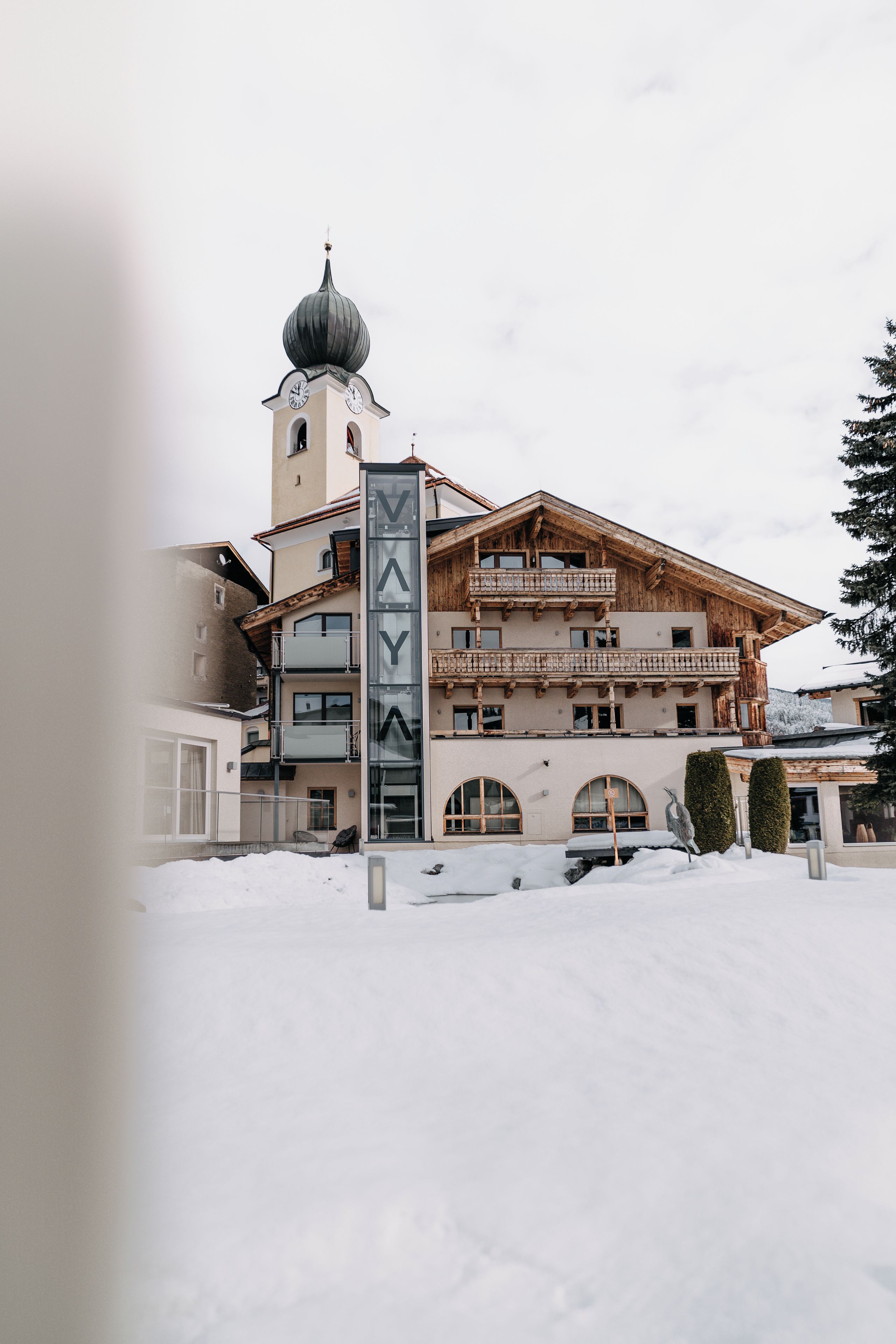 A multi-story building with a prominent clock tower and a ski resort facade.