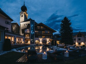 Un hotel con piscina, zona de estar al aire libre y un campanario.