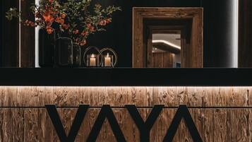 A reception area with a wooden reception desk and a large 'VAYA' sign.