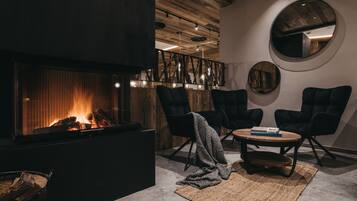Ein modernes Interieur mit Kamin, Holzboden und schwarzen Polsterstühlen.