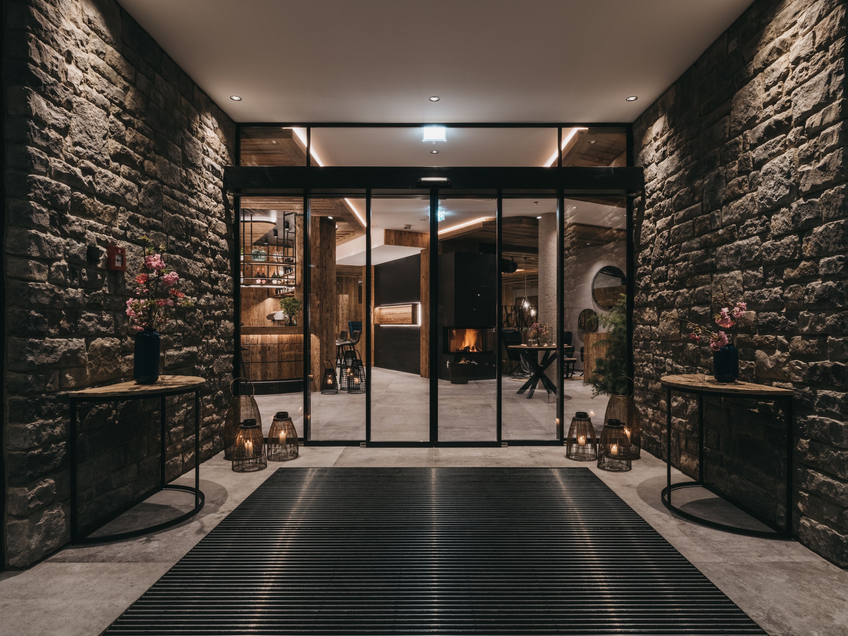 Ein modernes Interieur mit einer Steinsäule, einer Rezeption und einem Kamin.