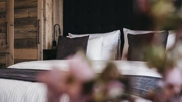 A bedroom with a bed, wooden wardrobe, and a black headboard.