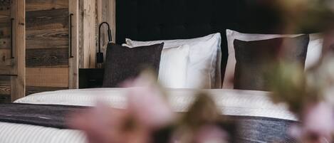 A bedroom with a bed, wooden wardrobe, and a black headboard.