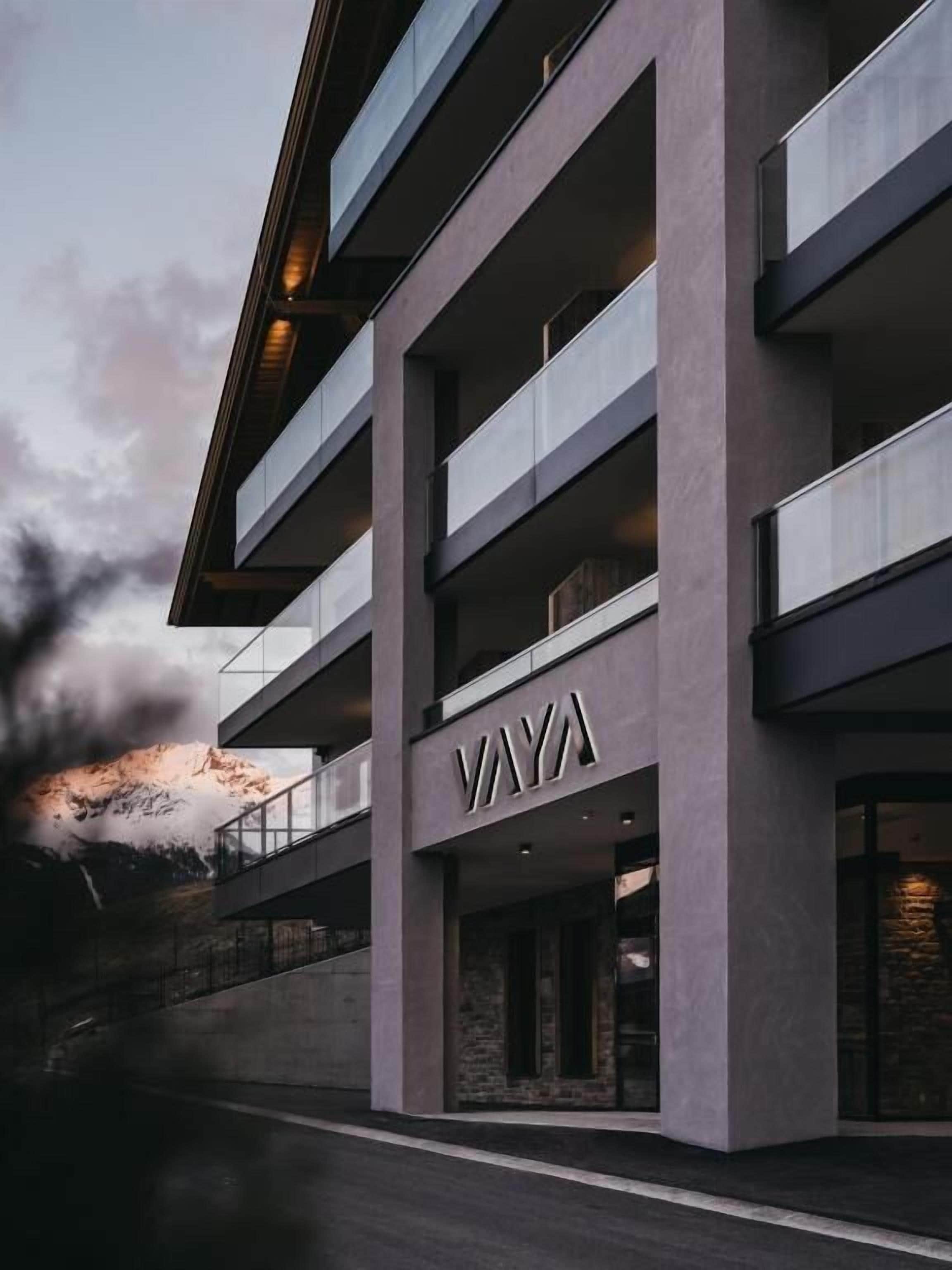 Un immeuble à plusieurs étages doté d’une architecture moderne, avec une enseigne « VAYA » bien visible sur la façade.