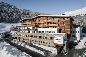 Ein mehrstöckiges Gebäude mit Holzfassade und einem Schild mit der Aufschrift "VAYA BAR & GRILL".