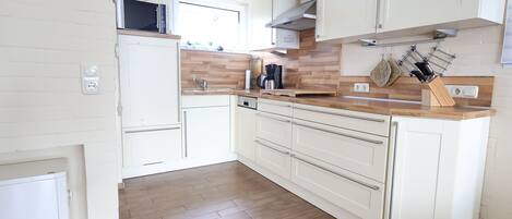 Kjøleskap, mikrobølgeovn, oppvaskmaskin og høy barnestol