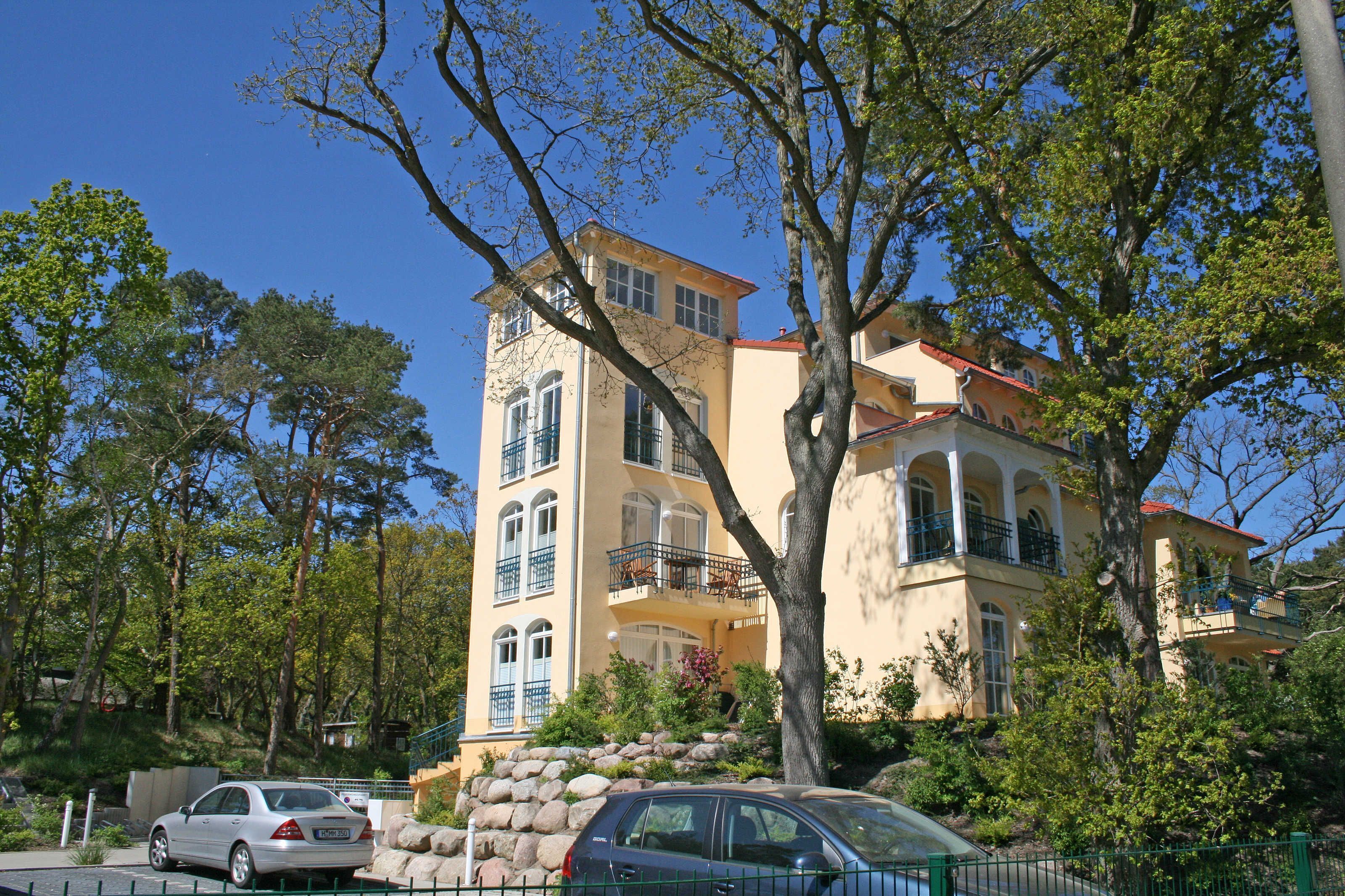 A multi-story building with balconies and a stone facade.