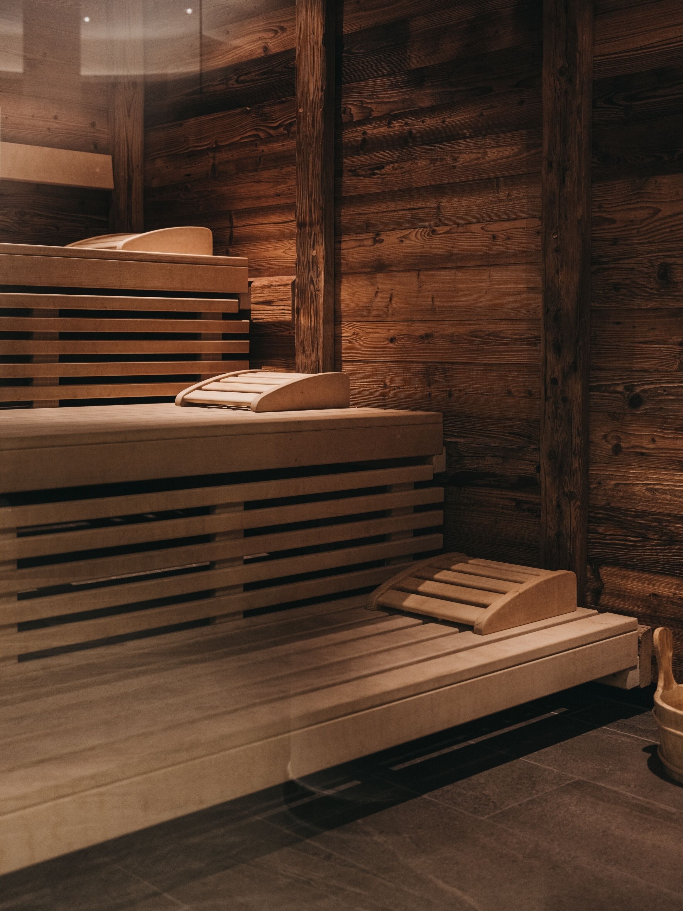 Una sauna con bancos de madera y suelo de baldosas.