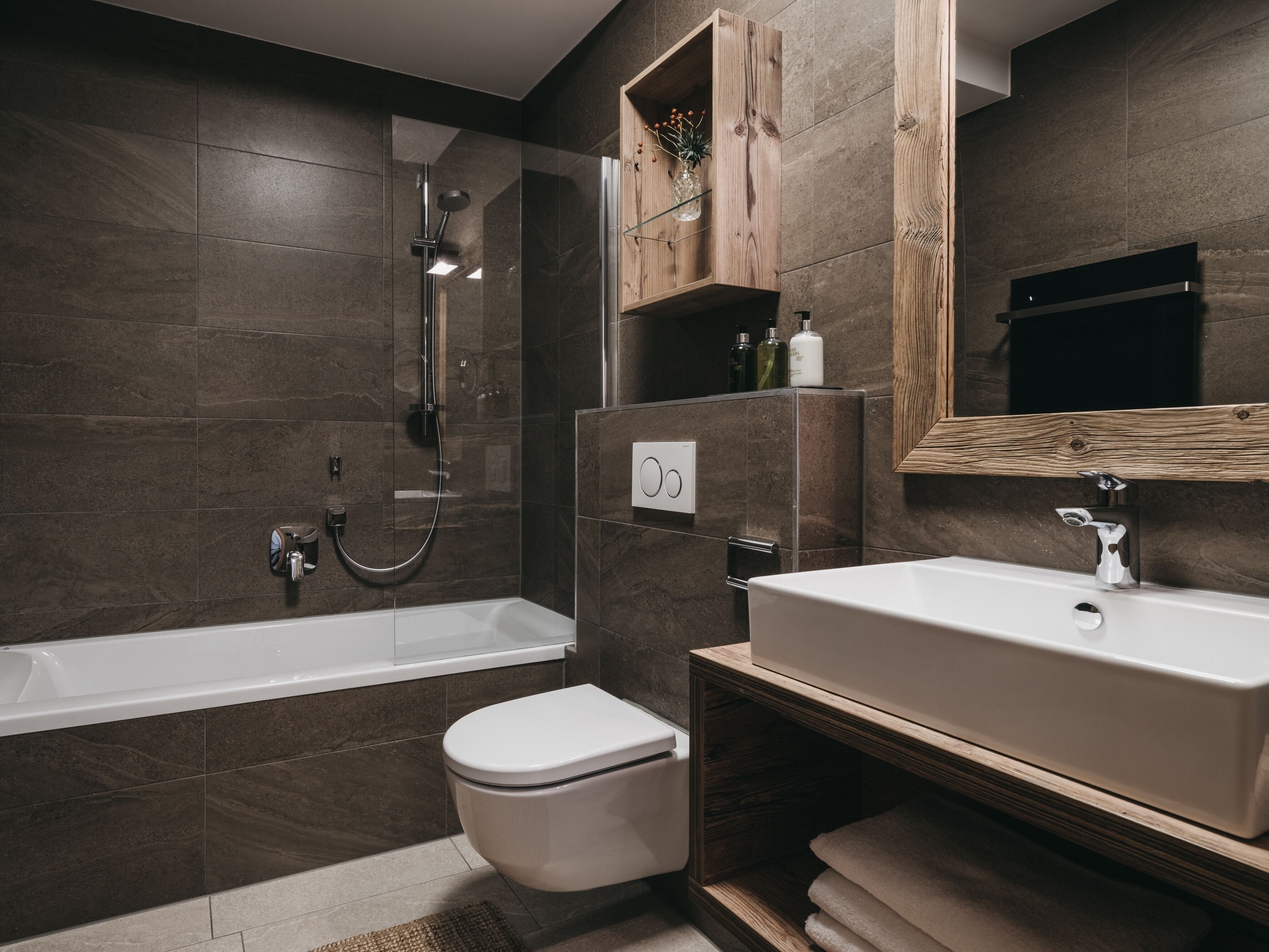 A modern bathroom with a bathtub, toilet, and sink.