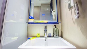 A bathroom with a sink, mirror, and hairdryer.