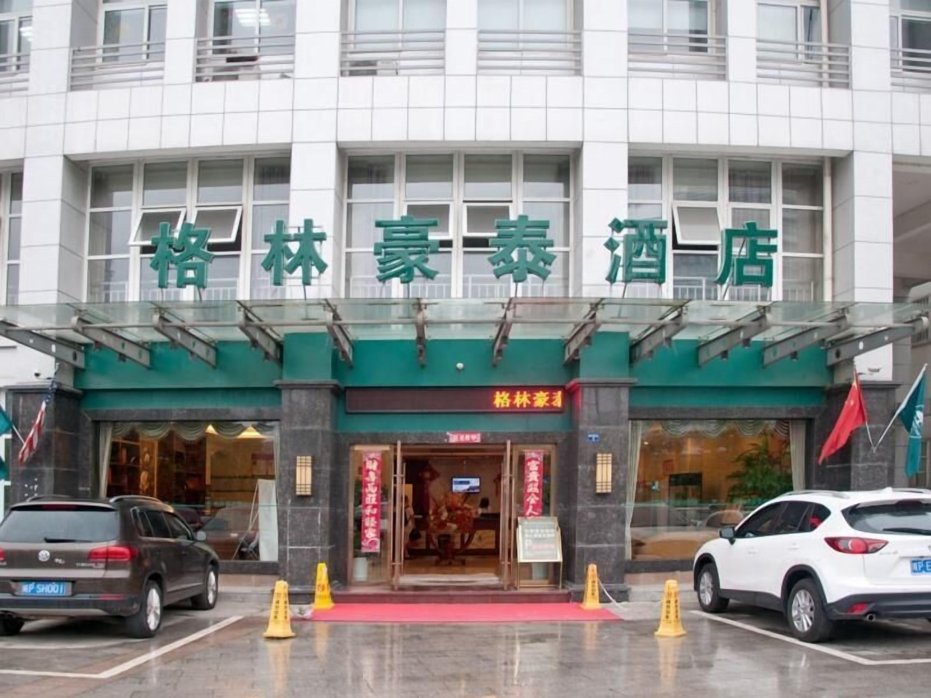 A hotel entrance with a green awning and signage.