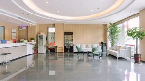 A modern hotel lobby with a reception desk, seating area, and a large plant. - Greentree Inn Anhui Xuancheng South Zhaoting Road Business Hotel (Xuancheng)