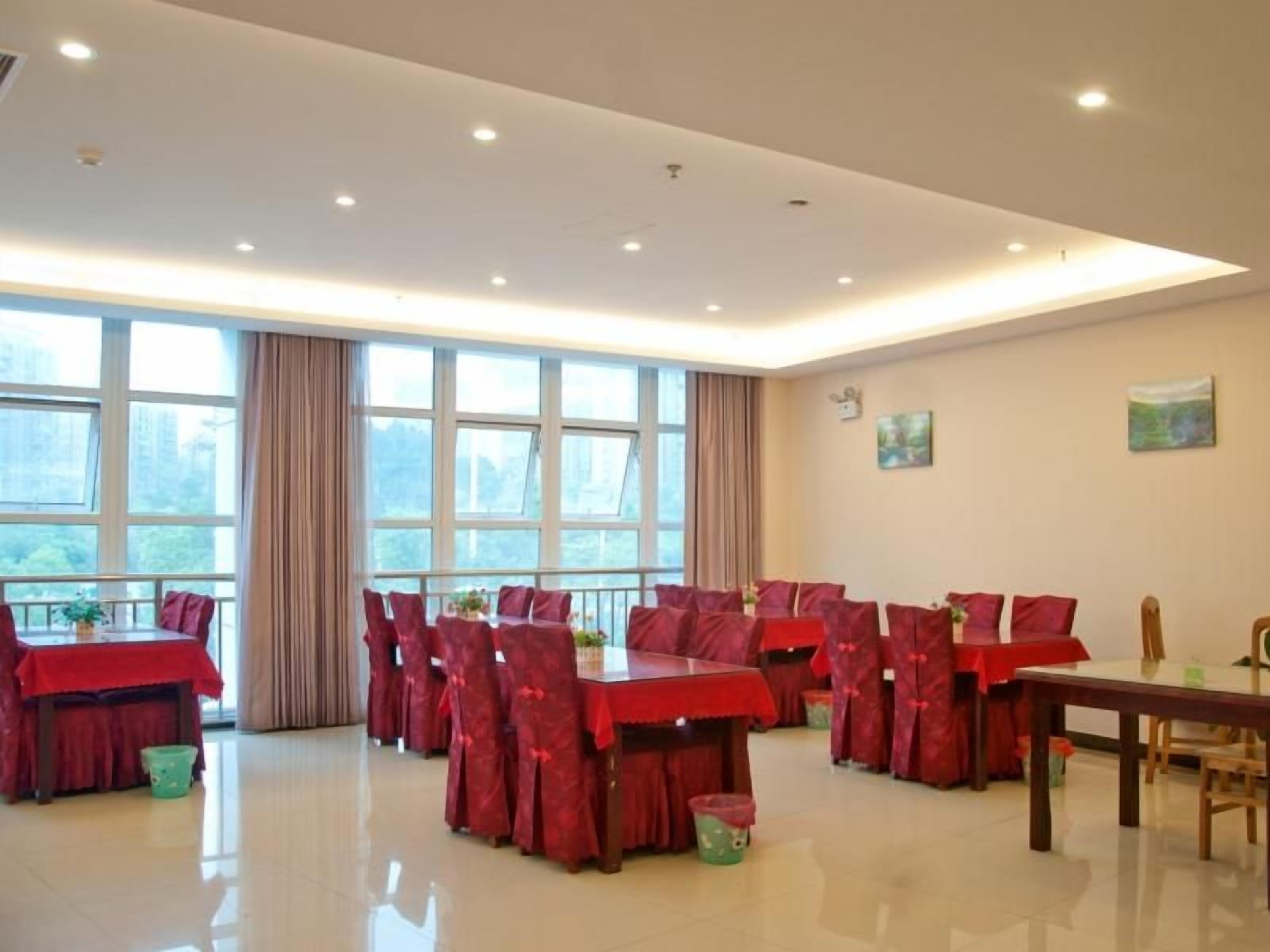 Un comedor amplio con varias mesas y sillas, ventanas grandes con cortinas, y un interior limpio y bien iluminado.