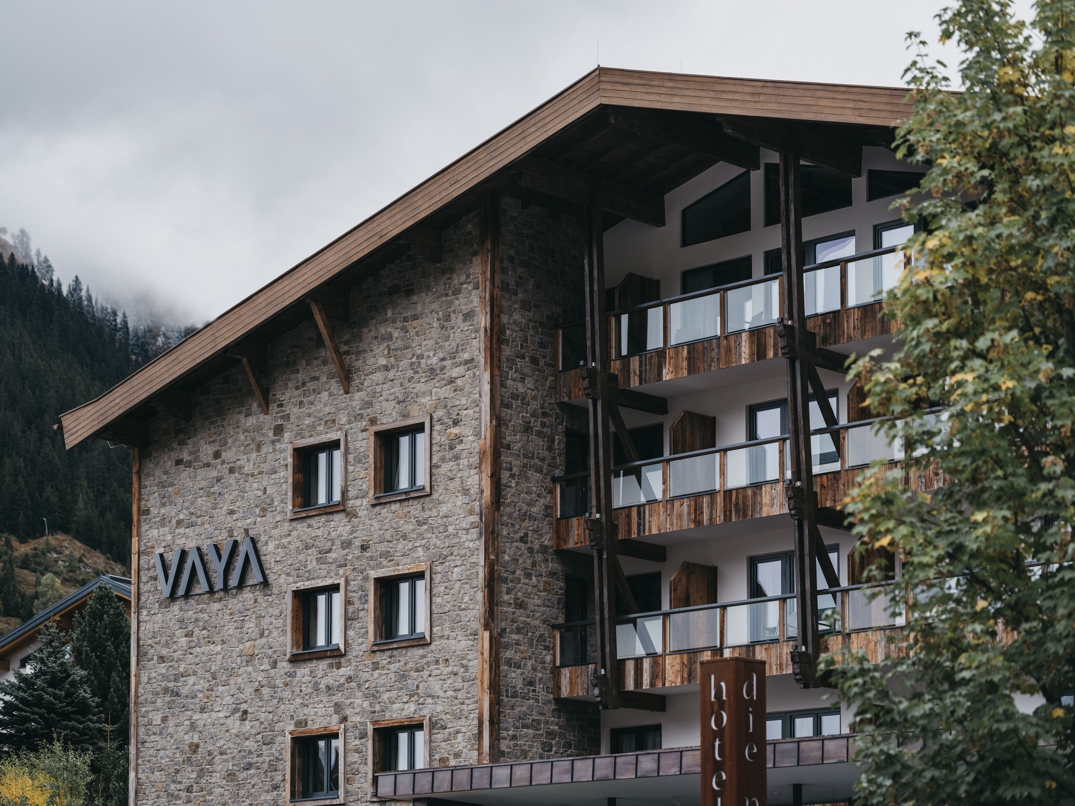A multi-story hotel with a stone facade and wooden balconies.