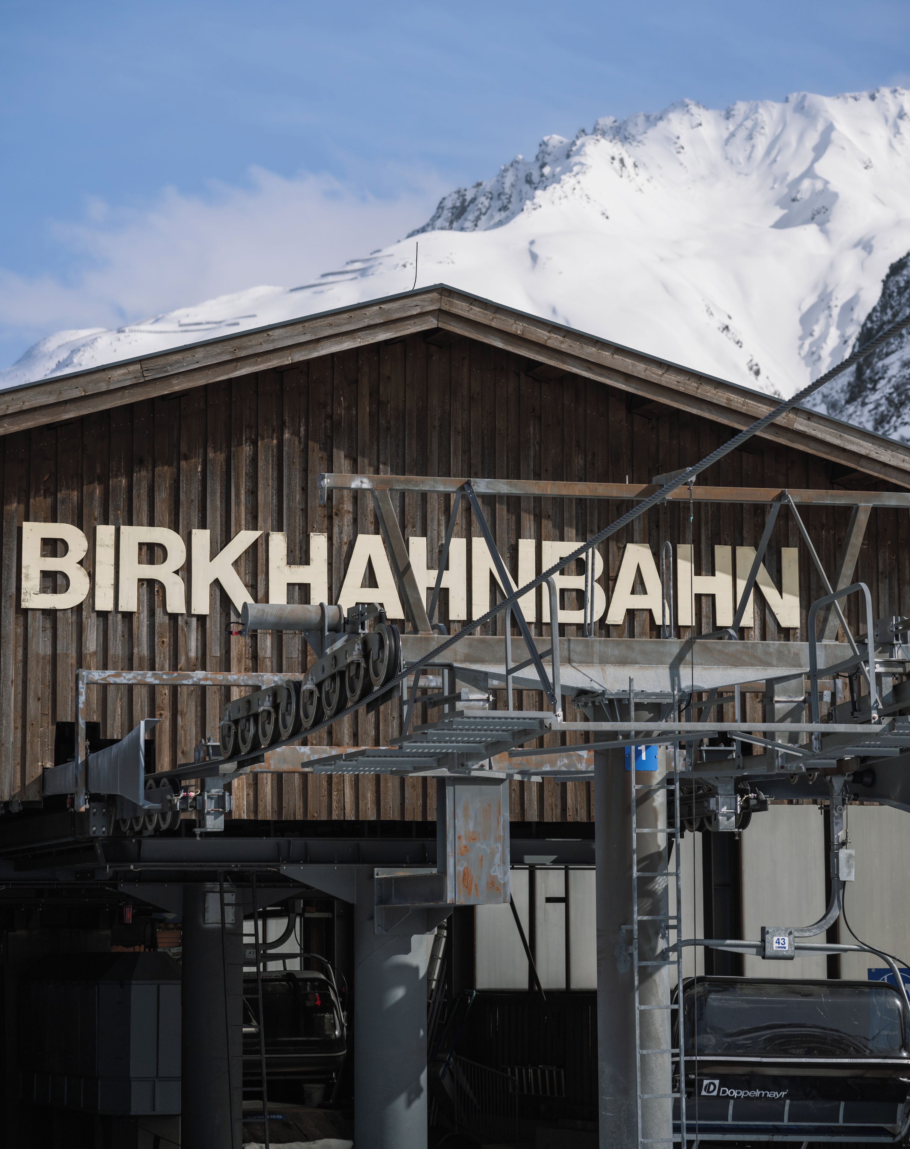 Un edificio de madera con el texto 'BIRKHABN' y una montaña al fondo.