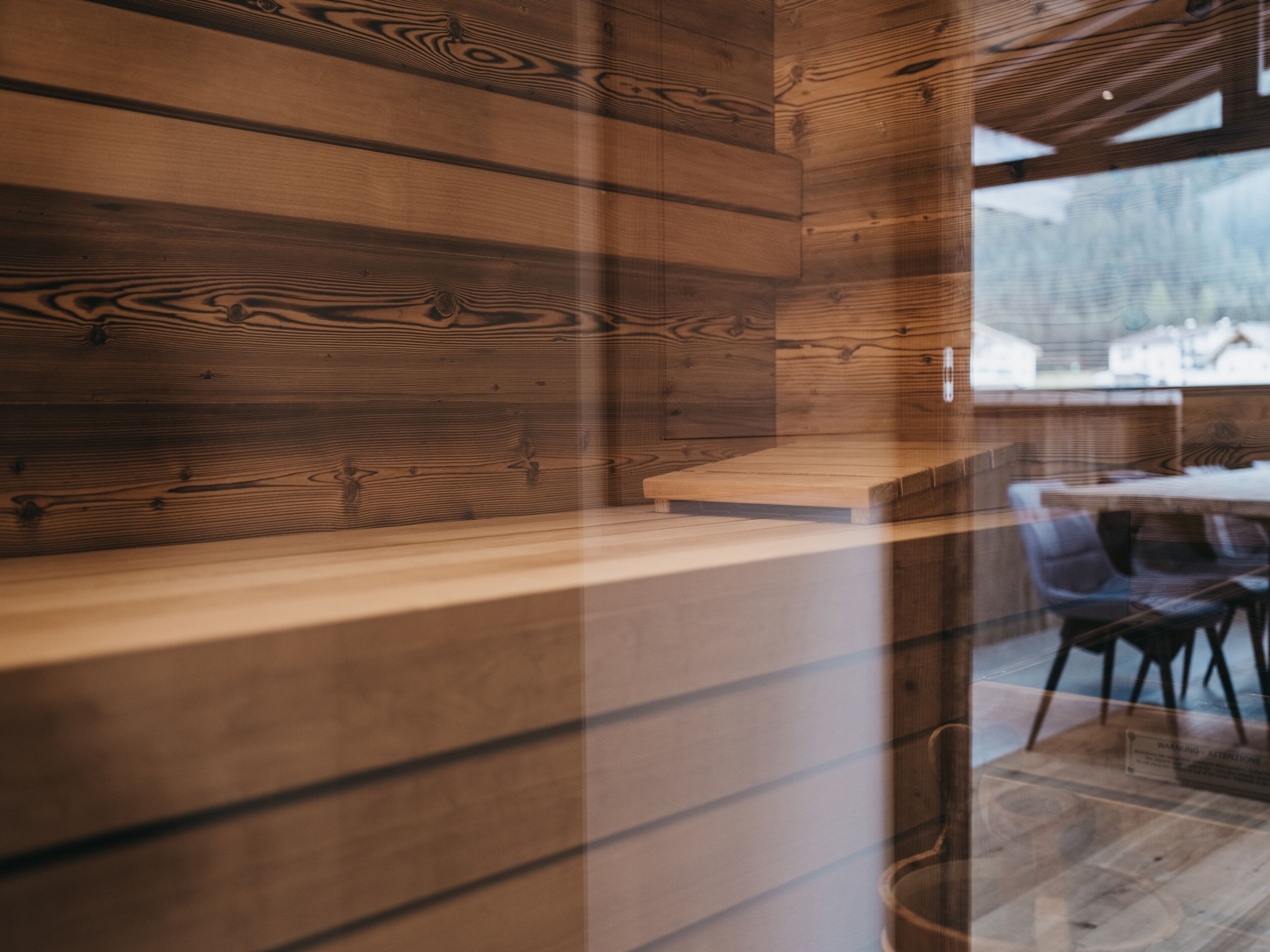 Un interior de madera con un banco y sillas de madera.