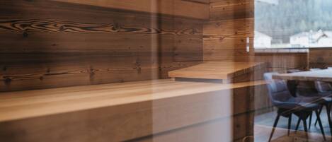 A wooden interior with a wooden bench and chairs.