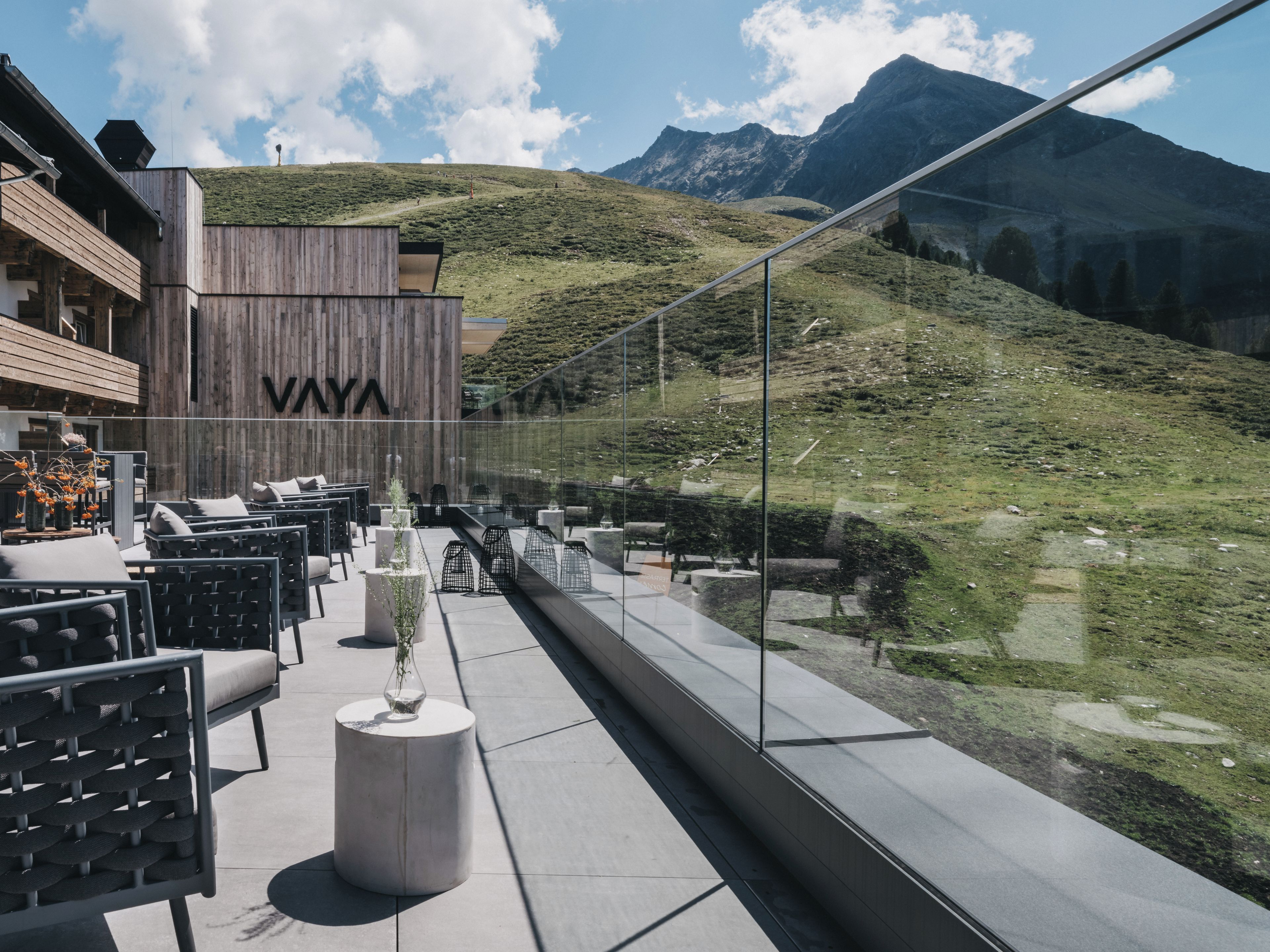 A modern outdoor seating area with a view of a mountainous landscape.