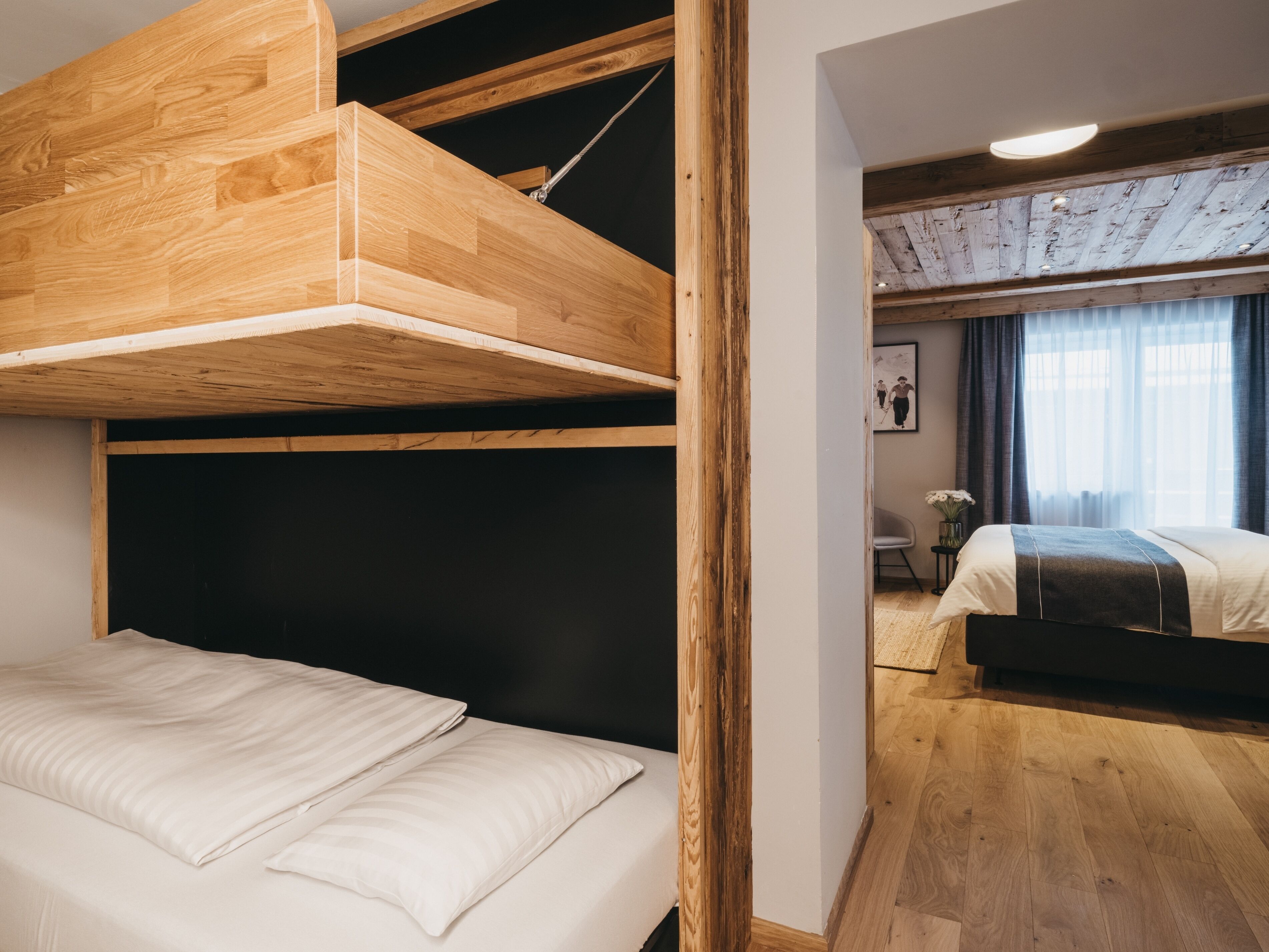 A room with a bunk bed, a desk, and a chair.