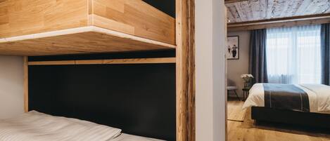 A room with a bunk bed, a desk, and a chair.