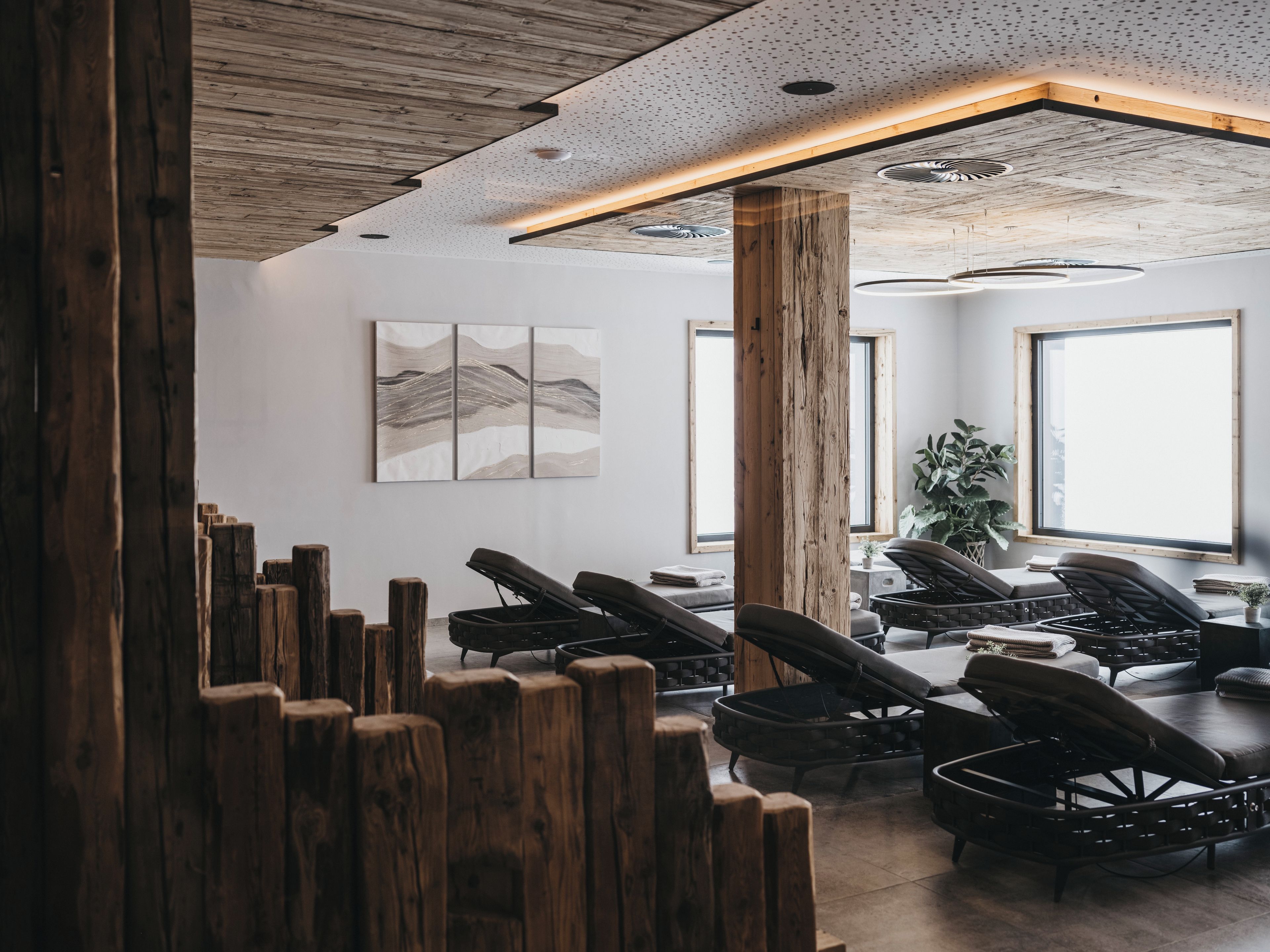 A modern interior with a wooden ceiling, a large window, and a seating area with chairs.