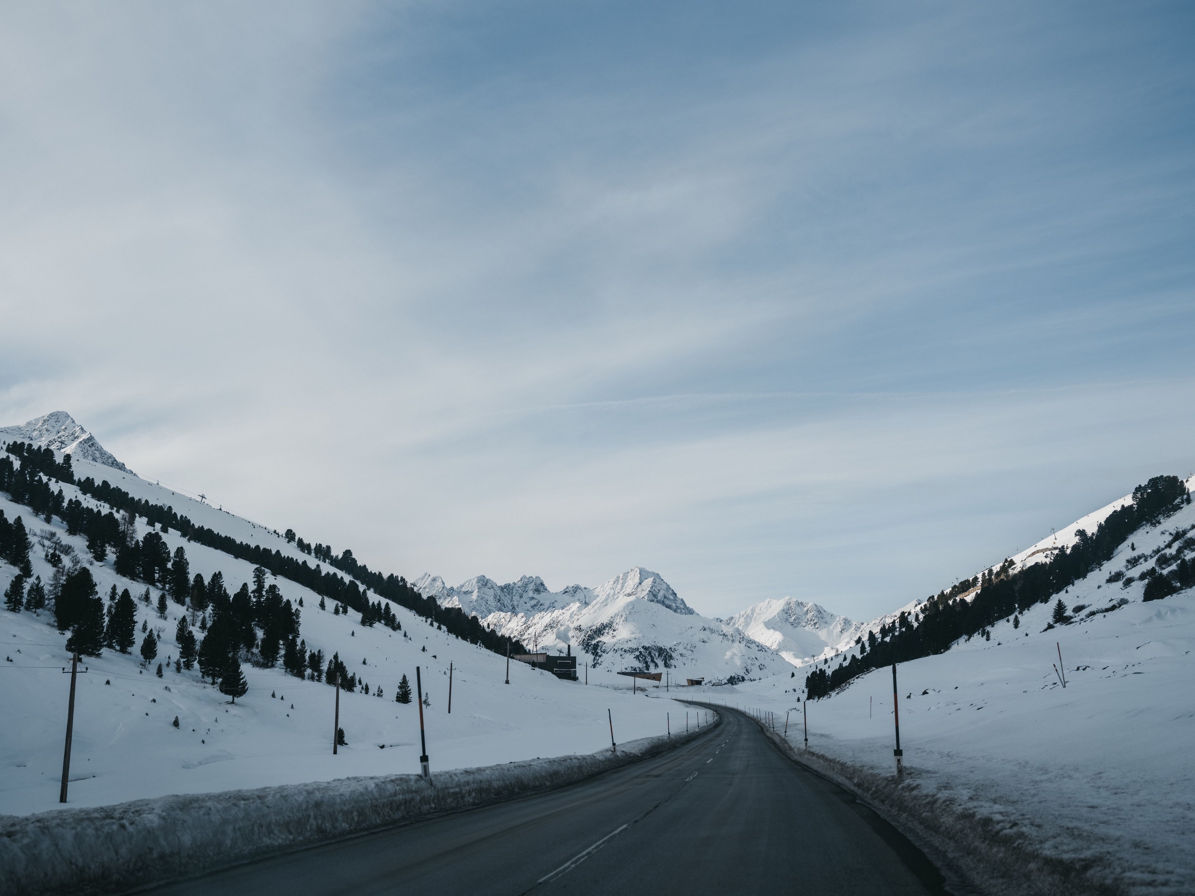 A snow-covered mountain road with a clear sky.